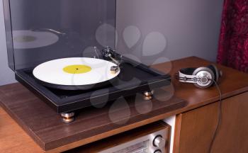 

Vintage Stereo Turntable Plays White Vinyl Record Album, angled view