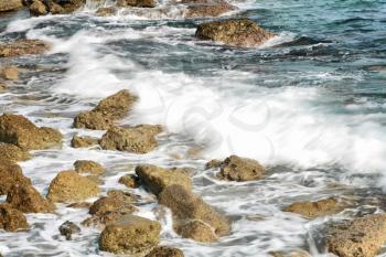 The rock on seashore with water and coming wave (HDR, long exposure)
