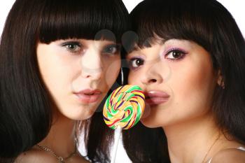 closeup of girls faces with rainbow lollipop isolated on white