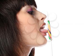 closeup of girls face in profile licking rainbow lollipop isolated
