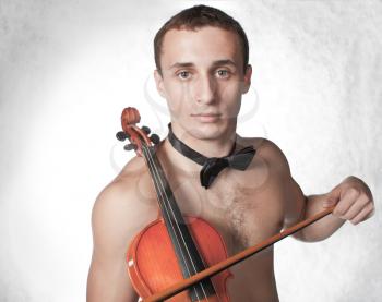 handsome guy shirtless with bow tie having fun with violin (low saturation toning)