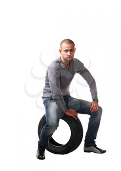 young latin male and car tyre isolated on the white background