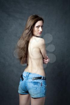 Isolated portrait of a beautiful and sexy young woman with a bare back.