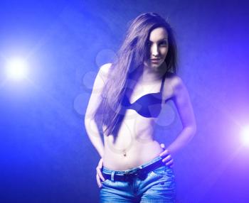 Sexy young self- confident brunette girl dancing in discolight