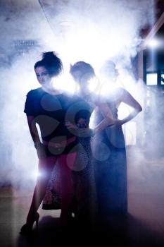 Three glamorous girls having fun at disco in night club