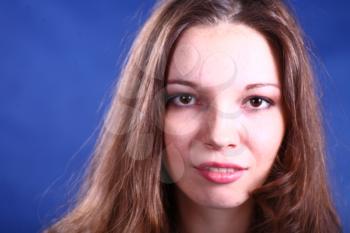 face of young beautiful woman enjoying on blue background