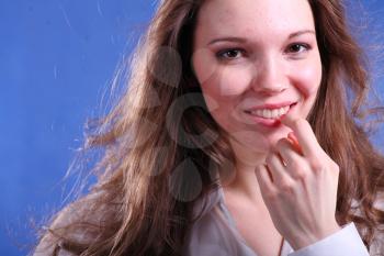 Face of a Pretty young woman touch to  lips - on blue background