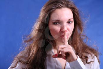 Face of a Pretty young woman touch to  lips - on blue background