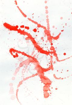 Blot of red watercolor on white paper