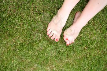 Womans bare feet on the fresh green grass