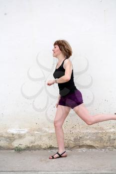 adult women jogging by wall in city