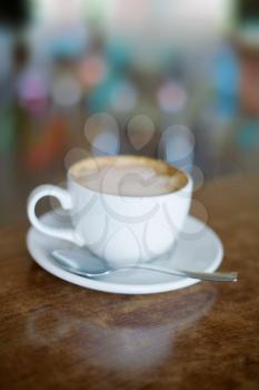 White Coffee Cup on brown wooden table with bokeh