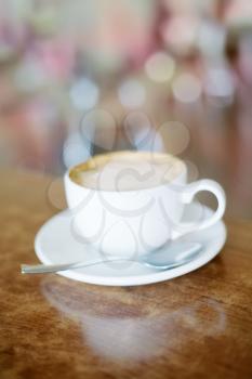 close up of  a delicious cup of coffee on wooden table.