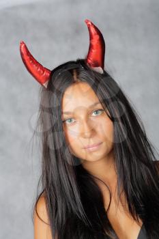 sexy devil with long hair against grey background