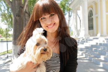woman beautiful young happy with long dark hair in striped dress holding small dog