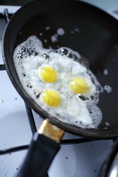 Broken egg frying in a pan