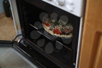 photograph of cooking pizza in the oven or stove