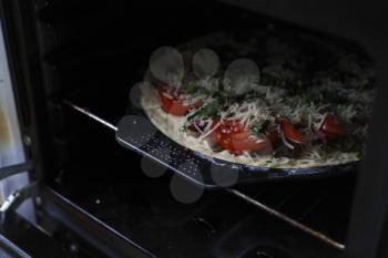 photograph of cooking pizza in the oven or stove