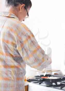 Beautiful Young Woman cooking indoors