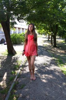 Portrait of a sexy young female in a park in red dress