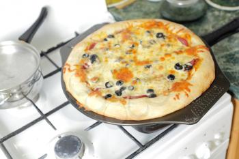 pizza capricciosa on dish in the kitchen