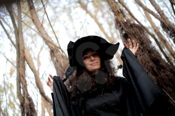 Sexy  girl in witch costume for Halloween in a forest