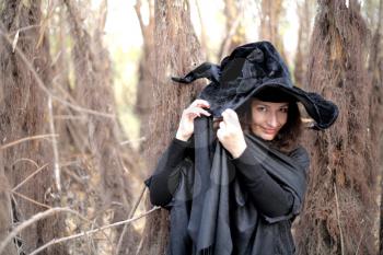 Sexy  girl in witch costume for Halloween in a forest