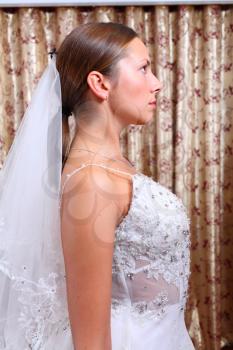 beautiful bride wearing off shoulder dress and with  wearing veil in profile