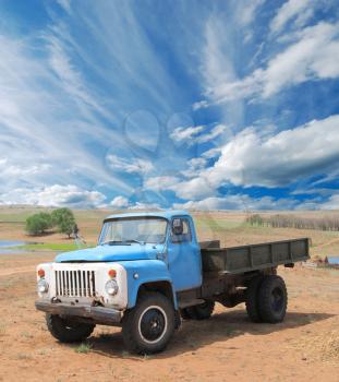 Old blue farm truck fading in time in desert 