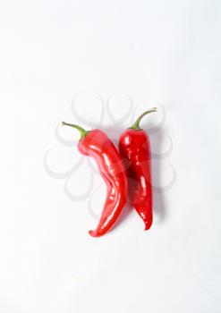 two red hot chili peppers on white background