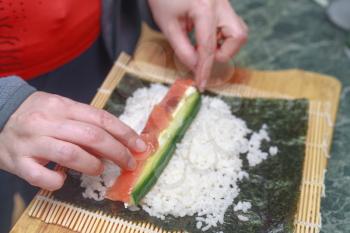 An image of women making california roll close-up