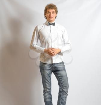 young fashion male model wearing bow tie  on gray background