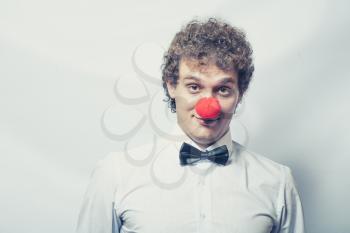 Young studen or Businessman with a red clown nose. Studio shot. Head and shoulders. Toned image