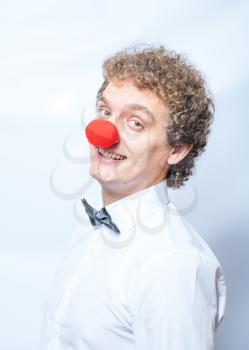 Funny businessman with red clown nose studio shot. Concept or idea of unusual things.