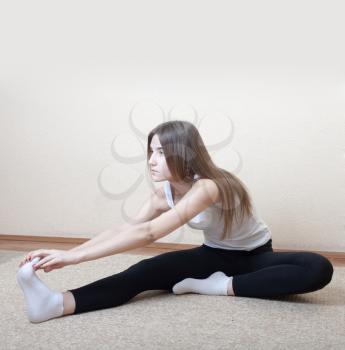 Young Blond Woman do yoga stretching indoors. Fitness concept for health club