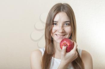 Beautiful blonde woman holding a red apple - health concept. Pretty smile deep blue eyes
