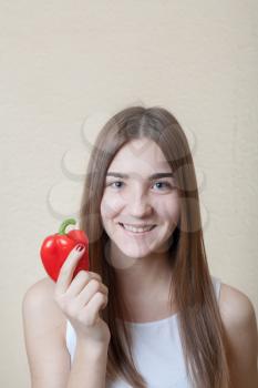 beautiful girl pretty smile with red sweet pepper head and shoulders shot - organic food and health concept