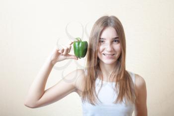 beautiful girl with green sweet pepper - organic food and health concept