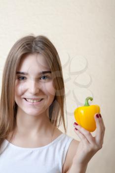 beautiful girl with yellow sweet pepper - organic food and health concept.