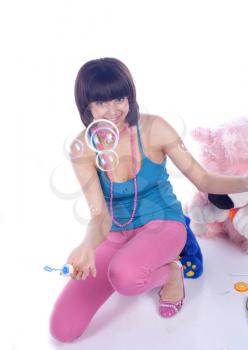 young beautiful brunette and soap bubble on white