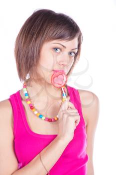Lovely girl with a heart-shaped candy on white