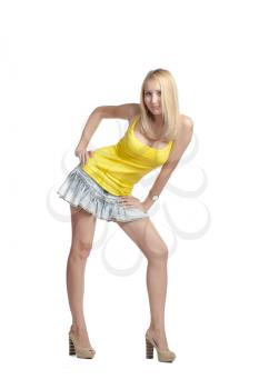 charming long-haired blonde in a yellow tank top and skirt white background isolated