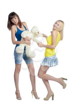 Two girls blonde and brunette with teddy bear isolated on white