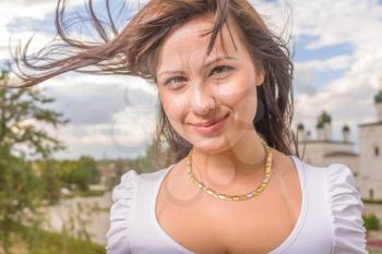 Closeup portrait of a happy young woman smiling on wind