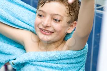 boy after bath warped in blue towel playing