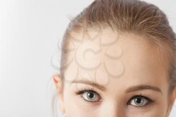 Half woman face with copy-space on side. Beautiful caucasian woman portrait on white background. Skincare beauty treatment concept. Close up of female eyes looking at camera - over a white background