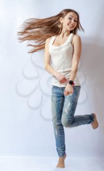 Young female dancing, fluttering on the wind hair, over white background