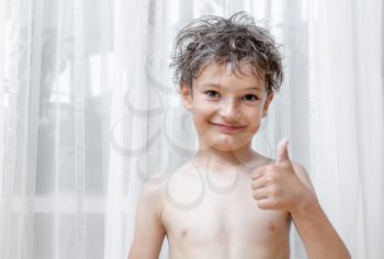 boy showing ok sign on white indoors smiling