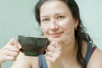 Close-up of a beautiful girl in front view with a cup near the face