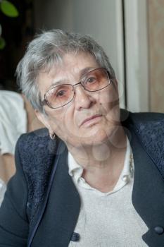 Portrait of senior woman, looking at camera. Blank expression . Indoors